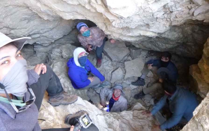 a group of gap year students smile while looking up from a rocky canyon
